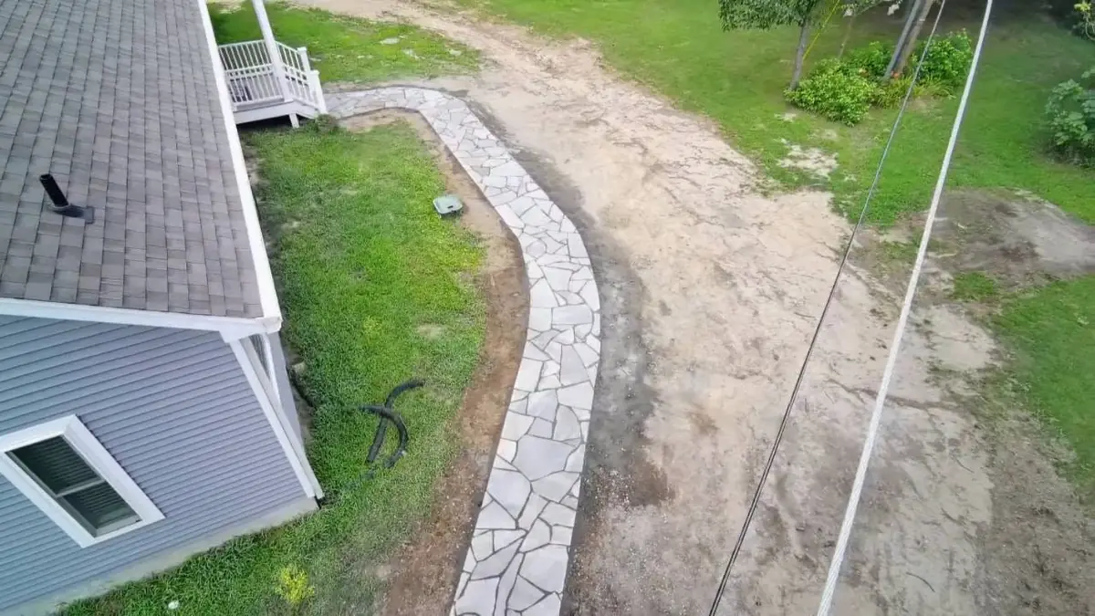 Completed flagstone walkway wrapping around a home