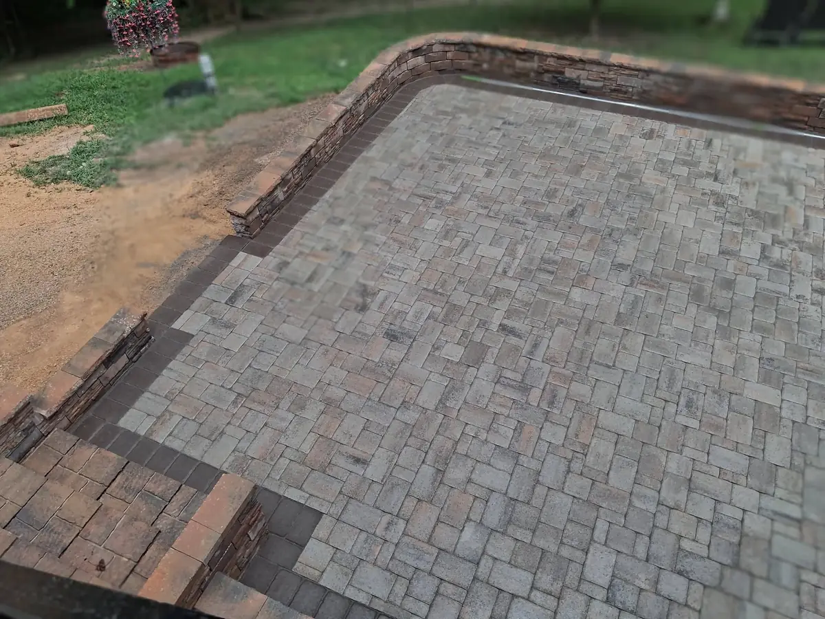 Completed multi-level paver patio with retaining walls and steps